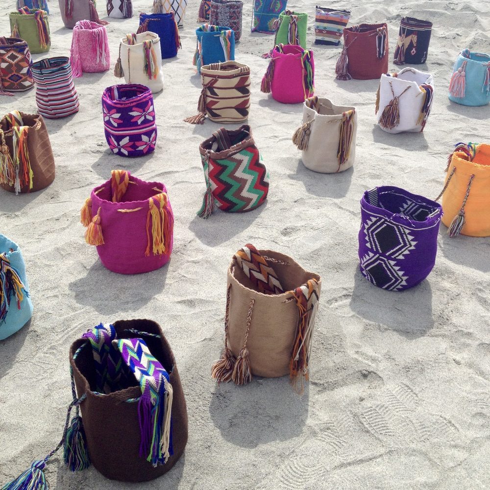 Bolsos de colores puestos en la arena