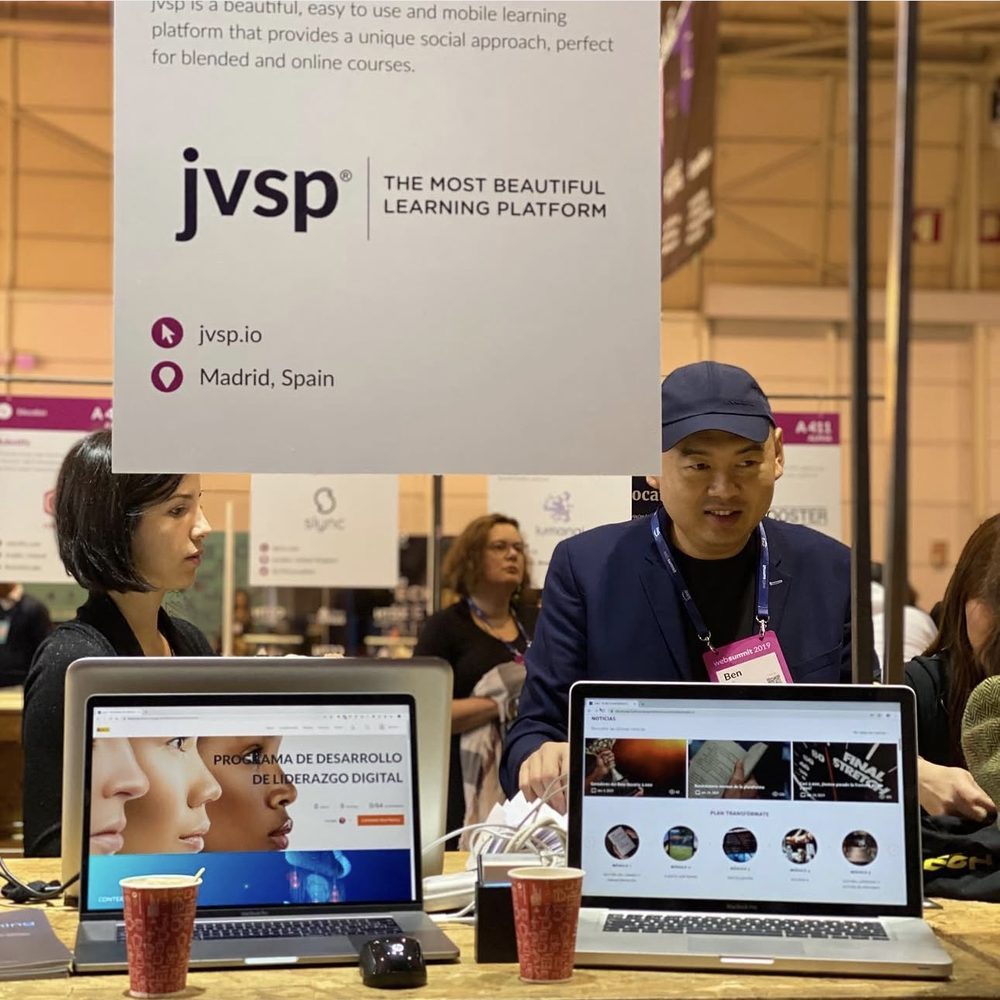Estand de JVSP en una feria, y Pablo dando una charla delante de una pantalla