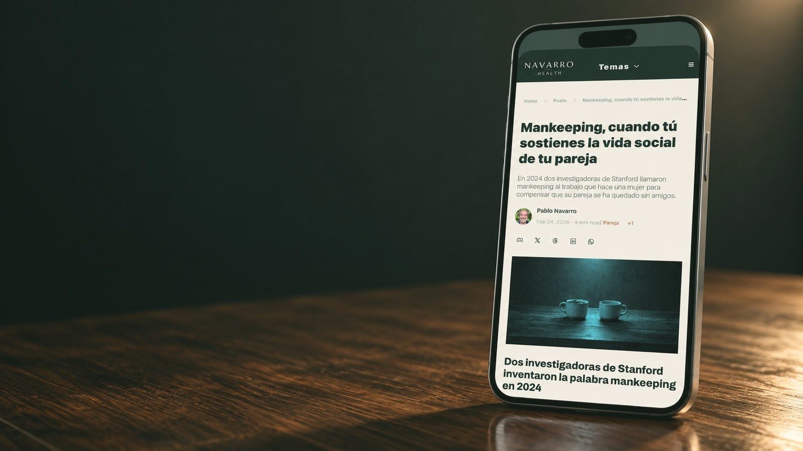 Un móvil sobre una mesa de madera con un artículo del newsletter abierto